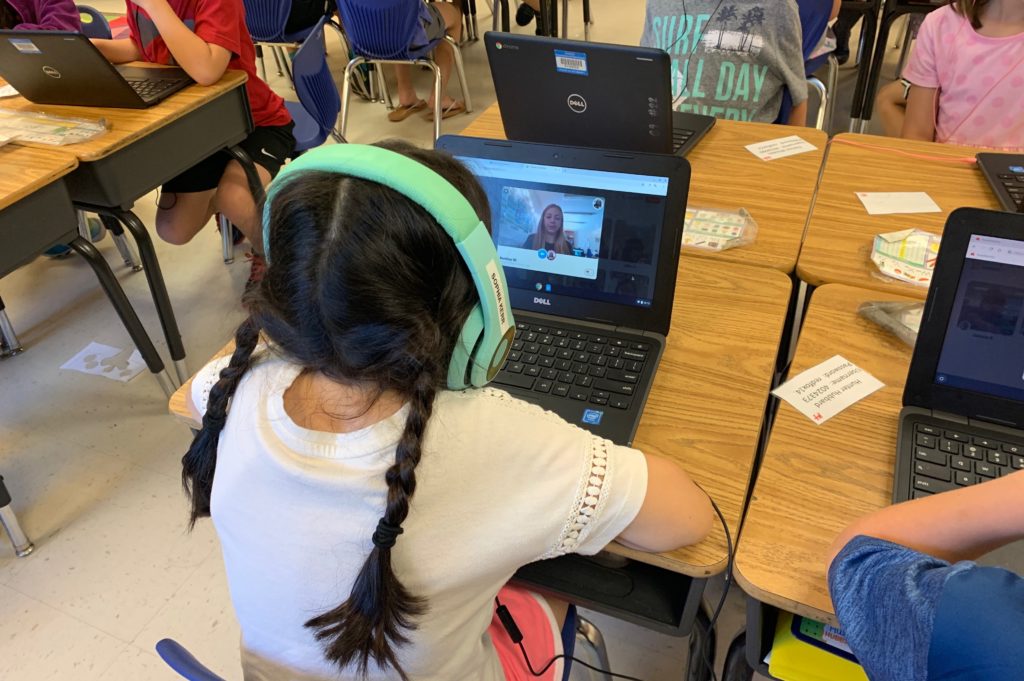 Girl with headphones on listening to computer. 