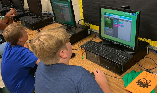 Two boys looking at computer screens.