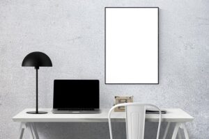Computer and lamp on a table with chair and hanging poster.  Image by BUMIPUTRA from Pixabay. 