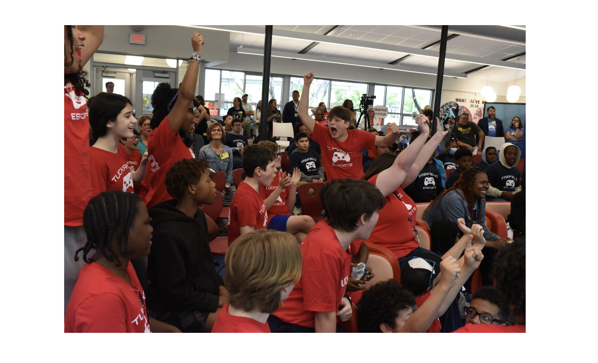 Middle school students in red shirts, cheering